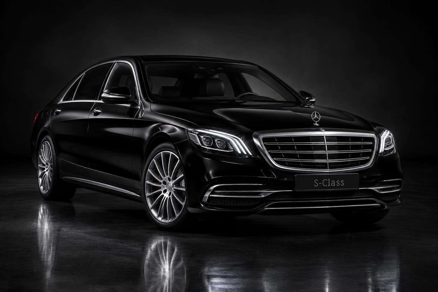 Black Mercedes-Benz S-Class luxury sedan on a dark studio background